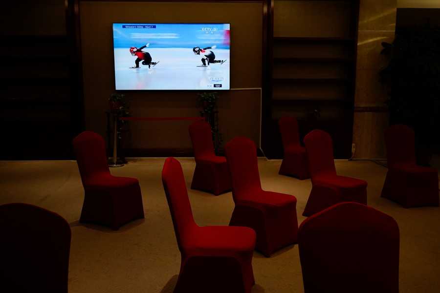 Beijing Olympics Getting A Glimpse Photo Gallery A TV in the lobby area of a media hotel shows news of a women's short track speed skating competition.