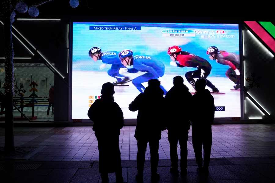 Beijing Olympics Getting A Glimpse Photo Gallery Residents watch a big screen showing China's team in the mixed team relay final during the short track speedskating competition.
