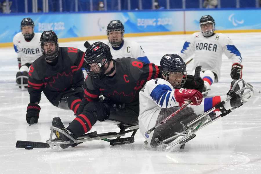 Paralympic Games South Korea's Choi Kwang-hyuk, right, battles for the puck against Tyler McGregor of Canada during they para ice hockey preliminary match at the 2022 Winter Paralympics, Tuesday, March 8, 2022, in Beijing.