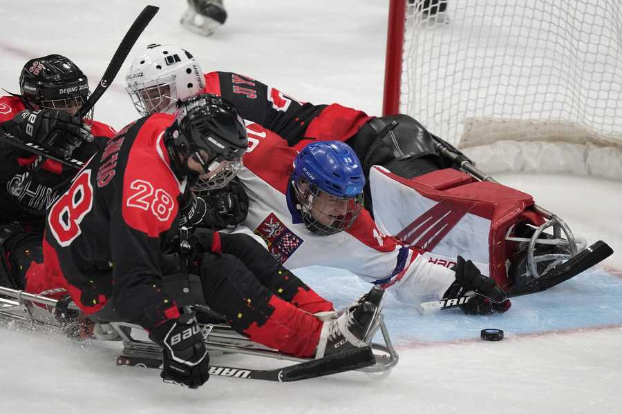 Paralympic Games Czech Republic's Alex Ohar, center, battles for the puck against China's Tian Jintao during their para ice hockey match at the 2022 Winter Paralympics, Sunday, March 6, 2022, in Beijing.
